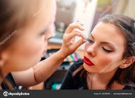 artist applying makeup female model