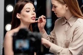 makeup artist applying lip gloss