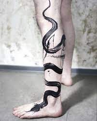 A coiled snake tattoo shows the world that you have a deadly persona lurking underneath your seemingly composed and collected exterior. Black Paint Brush Stroke Snake Tattoo On The Leg Done By Lina Tattoo Artist Www Otziapp Com Tattoos Snake Tattoo Design Tattoo Artists
