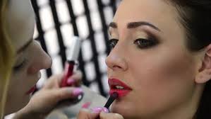 makeup artist applying lipstick to the