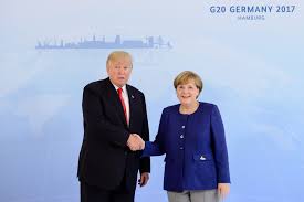 The massive billboard shows german chancellor angela merkel's fingers forming her trademark merkel rhombus. The Merkel Trump Handshake Heard Round The World Cnn Politics