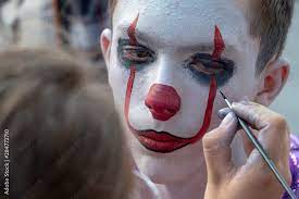 makeup artist paints a clown s face