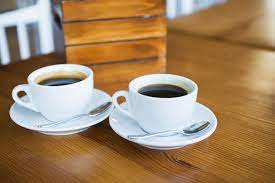 two cups of coffee on a wooden table