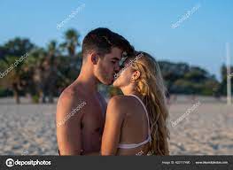 cute couple kissing beach stock photo