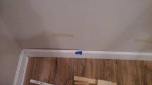 install baseboard trim over uneven wall