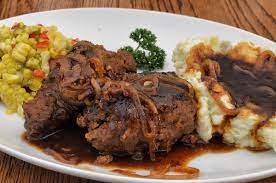 Once the meat patty is formed, it is then fried, and smothered with a rich creamy onion gravy. Salisbury Steak Wikipedia