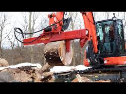 excavator splitting firewood with