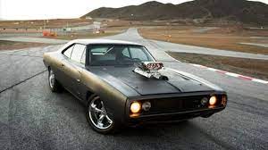 a black muscle car is driving