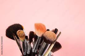 makeup brushes on pink background stock