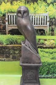 bronze owl on plinth garden