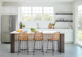 White kitchen cabinets are mounted over marble ogee tiles and beside a window positioned above white cabinets contrasted with a dark gray quartz countertop. Kitchen Windows Design Ideas White And Light Pella