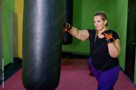 a fat woman is training kickboxing in
