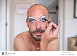 bearded man applying makeup on eyes a