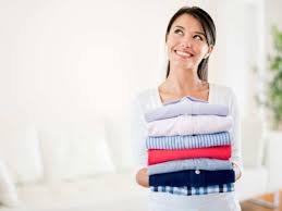 woman holding folded clothes