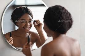 beautiful black lady applying makeup in