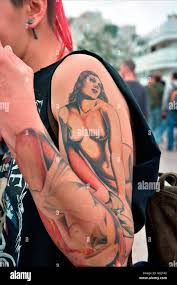 Ein junger weiblicher Punk mit einem großen Tattoo sexy nackte Frau auf  ihren Arm und hand Stockfotografie - Alamy