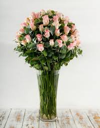 100 pink roses in a tall glass vase