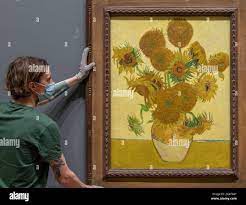 The National Gallery, London, UK. 21 June 2021. National Gallery art  handlers rehang the Vincent van Gogh Sunflowers, painted 1888, early on  Monday morning 21st June, the summer solstice, before the Gallery