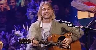 With a gravelly voice, blue eyes peeking out from curtains of blond hair, and an expression. Remembering Kurt Cobain Today On What Would Have Been His 54th Birthday Born 2 20 67