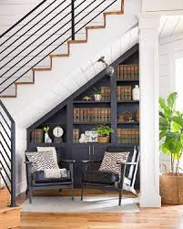 A vintage graphite grey bookcase, lamps and comfy chairs for creating a cozy reading nook under the stairs reading nook with shelves and a comfy lounge chair and enough light Cabinet Under The Stairs In A Private House Stylish And Practical Solutions Make Simple Design