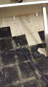 wet asbestos floor tile and black adhesive