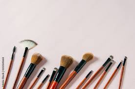 diffe makeup brushes on pastel pink