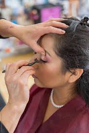 makeup artist applying false eyelashes