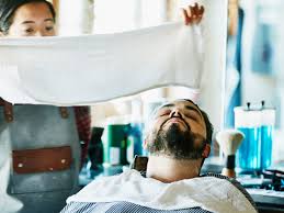 barber puts a hot towel on your face