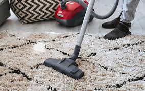 person vacuuming hoovering carpet rug