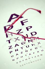 A Pair Of Black Reading Glasses On Top Of An Eye Test Chart