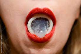 Condom on girl mouth. Red lips. Sexual concept Stock Photo | Adobe Stock