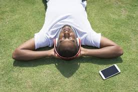 Relaxed black man resting in park and listening to music. - Nohat