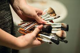 person holding makeup brushes beauty