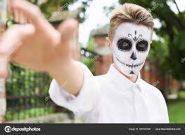 young man painted skull his face