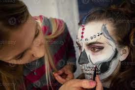 makeup artist puts greasepaint of a