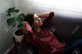 若い女性が彼女の頭に触れて、ソファで彼女の問題について考えていることを強調しました。欲求不満に見える欲求不満のヒスパニック系女性の写真素材・画像素材  Image 159265953