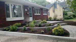 The paver design provides a nice, flat surface for the lawn mower wheels to roll along the flower bed edge and make a clean and beautiful cut. Stone Walkway Raised Flowerbeds Increase Curb Appeal A Touch Of Dutch Landscaping Garden Services Ltd