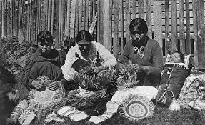 Tlingit women with infant in cradleboard weaving baskets, Alaska, ca. 1910 - American Indians of the Pacific Northwest -- Image Portion - University of Washington Digital Collections