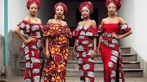 four women dressed in african dresses