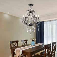 An art deco chandelier hangs from a white plank ceiling over an oval black dining table surrounded by gold metal dining chairs. Rosdorf Park Aren 5 Light Candle Style Empire Chandelier With Beaded Accents Reviews Wayfair