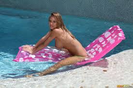 Nicole Aniston soaking wet in green gstring bikini on pink raft.