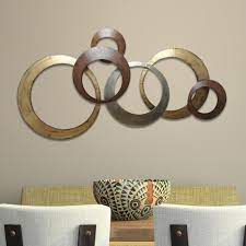 Made from metal with textured silver, gold, and brown plated circles and rings, this large statement piece is simple yet striking. Stratton Home Decor Metallic Rings Wall Decor Spc 999 The Home Depot In 2020 Metal Wall Art Decor Stratton Home Decor Metal Tree Wall Art