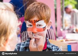 child boy face painting making tiger