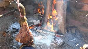 roasting wild boar leg over fire you