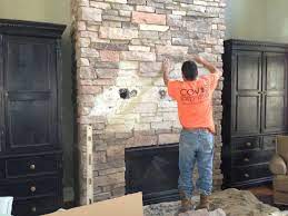 stacked stone fireplace with tv above