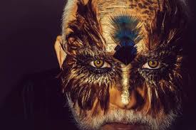 old man in feather mask stock image
