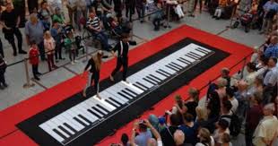 couple playing floor piano draws huge