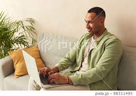smiling man working laptop at sofa guy