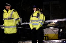 Police Officers Stand Guard Beside A Cordoned Off Area