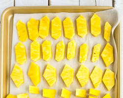 Image of Frozen pineapple chunks on a baking sheet